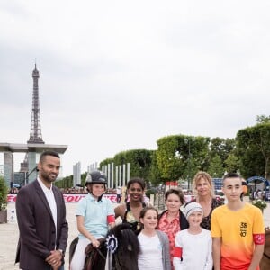 Tony Parker et Virginie Coupérie-Eiffel avec les enfants de la Kids Cup présentée par l'association "Sourire à la vie" lors du Paris Eiffel Jumping du Longines Global Champions Tour, le 5 juillet 2015 sur le Champs-de-Mars à Paris