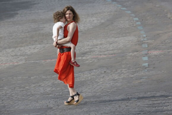 La compagne de Thierry Mandon et leur enfant lors du défilé du 14 juillet 2015, place de la Concorde à Paris.