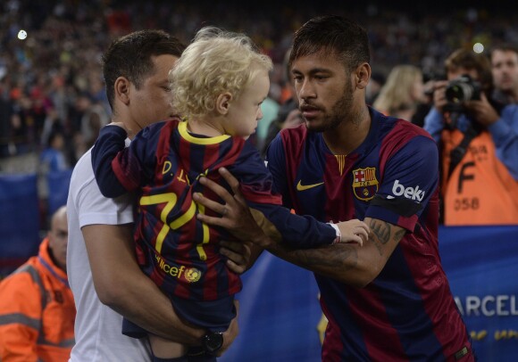 Le footballeur Neymar avec son fils David Lucca au Camp Nou à Barcelone, le 1er novembre 2014.