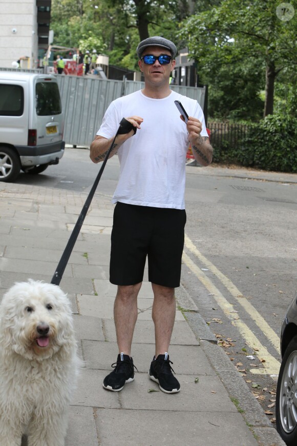 Exclusif - Robbie Williams promène son chien à Londres le 27 mai 2015.