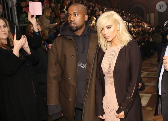 Kanye West, habillé d'un manteau Lanvin et d'un pull Vetements, assiste avec sa femme Kim Kardashian au défile Lanvin à Paris, le 5 mars 2015.