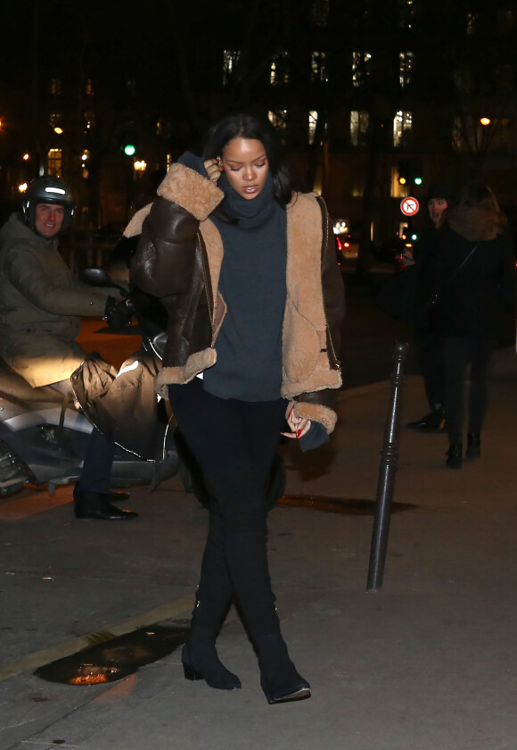 Rihanna arrive au restaurant Caviar Kaspia à Paris, habillée d'un manteau (collection automne-hiver 2015) et d'un pull à col roulé Vetements, d'un legging et de bottes Chanel. Le 18 janvier 2016.
