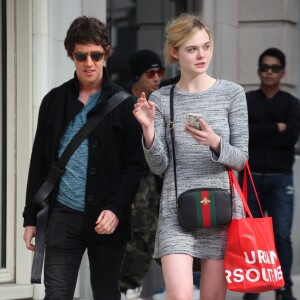 Elle Fanning quitte un magasin Urban Outfitters à Los Angeles, habillée d'une petite robe grise Michael Lauren (modèle "Harvest") et portant un sac Gucci et des chaussures Timberland. Le 16 janvier 2016.