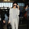 Kendall Jenner à l'aéroport LAX, porte un trench-coat, un top gris et un pantalon Sally LaPointe (pré-collection automne 2016), un sac Givenchy (modèle Nightingale) et des baskets Céline. Los Angeles, le 20 janvier 2016.
