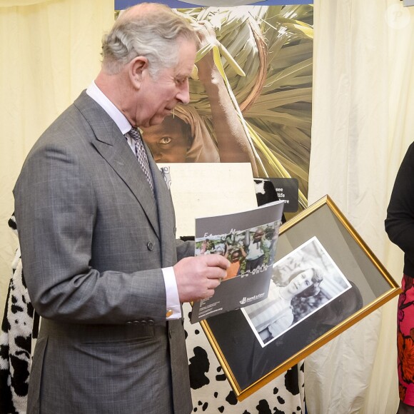 Le prince Charles découvre une photo de sa mère la reine Elizabeth II prise en 1939 lorsqu'elle avait 13 ans par Lawrence Audrain, lors d'une visite à l'association Send a Cow dont il est le président à Bath le 1er février 2016.