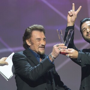 Johnny Hallyday reçoit la Victoire de l'album de chansons de l'année au côté de Yodelice (Maxim Nucci) qui a produit l'album "De l'amour" - Victoires de la musique au Zénith de Paris, le 12 février 2016.