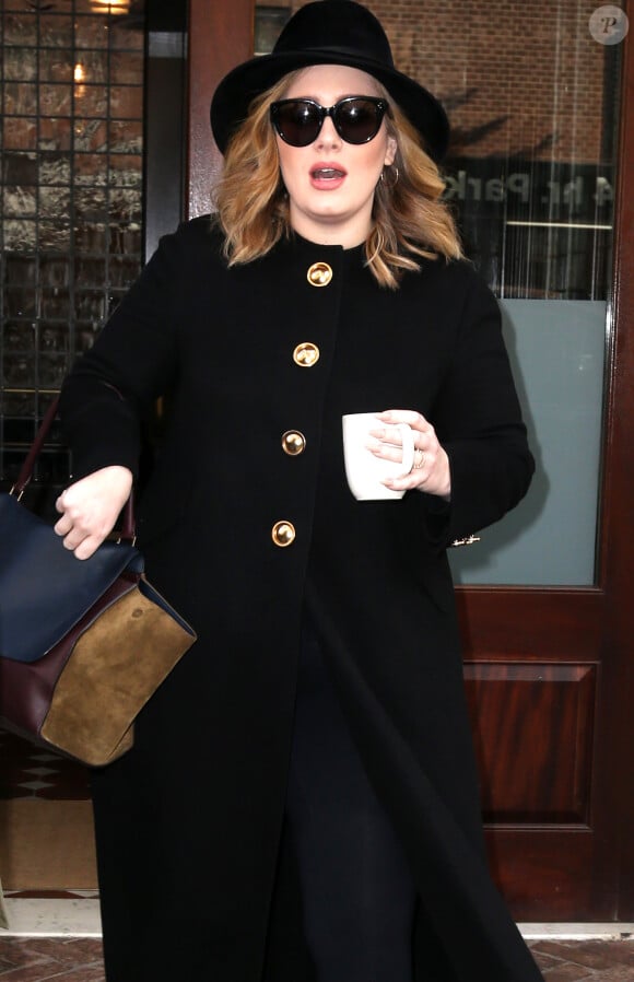 La chanteuse Adele sort avec une tasse la main d'un immeuble à New York, le 24 novembre 2015.