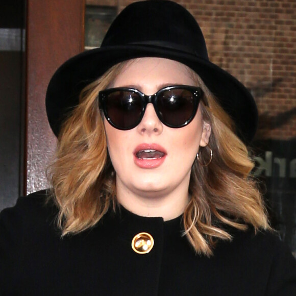 La chanteuse Adele sort avec une tasse la main d'un immeuble à New York, le 24 novembre 2015.