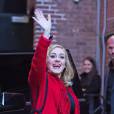 La chanteuse Adele salue ses fans habillée d'un manteau rouge au Joe's pub de New York le 20 novembre 2015