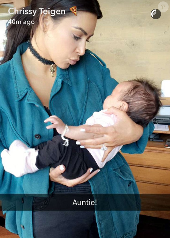 Kim Kardashian fait la connaissance de Luna, le bébé de Chrissy Teigen et John Legend lors d'un brunch au restaurant Nobu à Malibu. Photo publiée sur Snapchat, le 29 mai 2016.