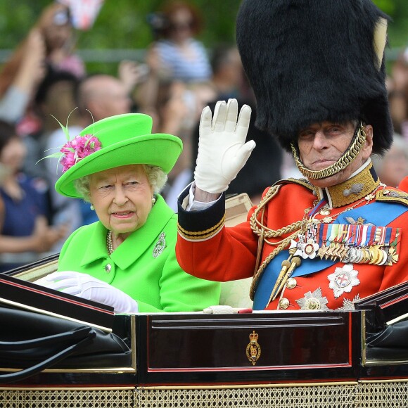 La reine Elizabeth II (dans un ensemble Stewart Parvin) et le prince Philip, duc d'Edimbourg, dans le Carrosse de la Reine découvert au cours de la procession sur le Mall lors de la parade Trooping the Colour, le 11 juin 2016 à Londres, en l'honneur du 90e anniversaire de la souveraine.