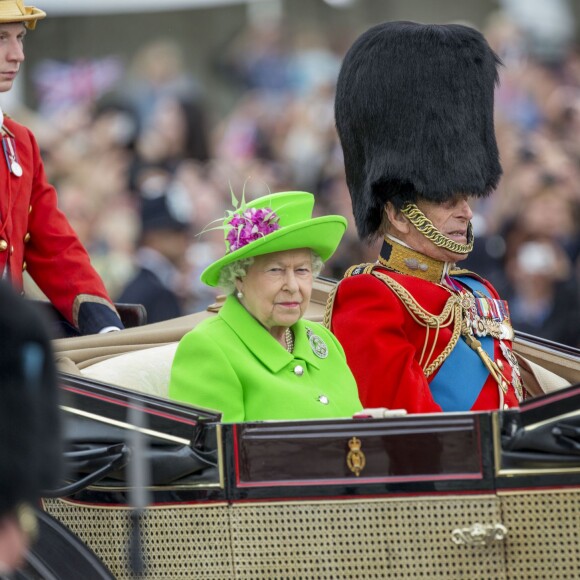 La reine Elizabeth II (dans un ensemble Stewart Parvin) et le prince Philip, duc d'Edimbourg, dans le Carrosse de la Reine découvert au cours de la procession sur le Mall lors de la parade Trooping the Colour, le 11 juin 2016 à Londres, en l'honneur du 90e anniversaire de la souveraine.