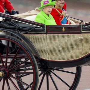 La reine Elizabeth II (dans un ensemble Stewart Parvin) et le prince Philip, duc d'Edimbourg, dans le Carrosse de la Reine découvert au cours de la procession sur le Mall lors de la parade Trooping the Colour, le 11 juin 2016 à Londres, en l'honneur du 90e anniversaire de la souveraine.