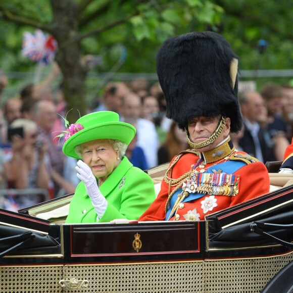 La reine Elizabeth II (dans un ensemble Stewart Parvin) et le prince Philip, duc d'Edimbourg, dans le Carrosse de la Reine découvert au cours de la procession sur le Mall lors de la parade Trooping the Colour, le 11 juin 2016 à Londres, en l'honneur du 90e anniversaire de la souveraine.