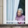 La reine Elizabeth II regardant par une fenêtre du Palais de Buckingham le 12 juin 2016 le Mall lors du Patron's Lunch, le pique-nique géant sur le Mall en l'honneur de son 90e anniversaire.