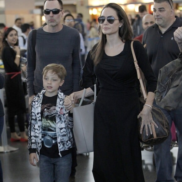 Angelina Jolie tenant la main de son fils Knox, son aîné Maddox les suit derrière - Arrivées à l'aéroport JFK de New York le 17 juin 2016.