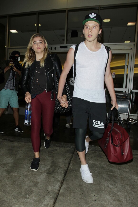Chloë Grace Moretz et Brooklyn Beckham arrivent à l'aéroport de LAX main dans la main à Los Angeles, Californie, le 29 juin 2016.