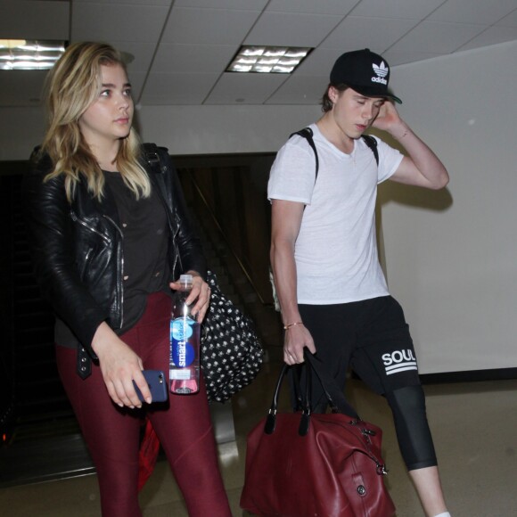 Chloë Grace Moretz et Brooklyn Beckham arrivent à l'aéroport de LAX main dans la main à Los Angeles, Californie, le 29 juin 2016.