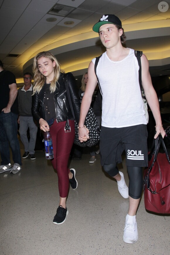 Chloë Grace Moretz et Brooklyn Beckham arrivent à l'aéroport de LAX main dans la main à Los Angeles, Californie, le 29 juin 2016.