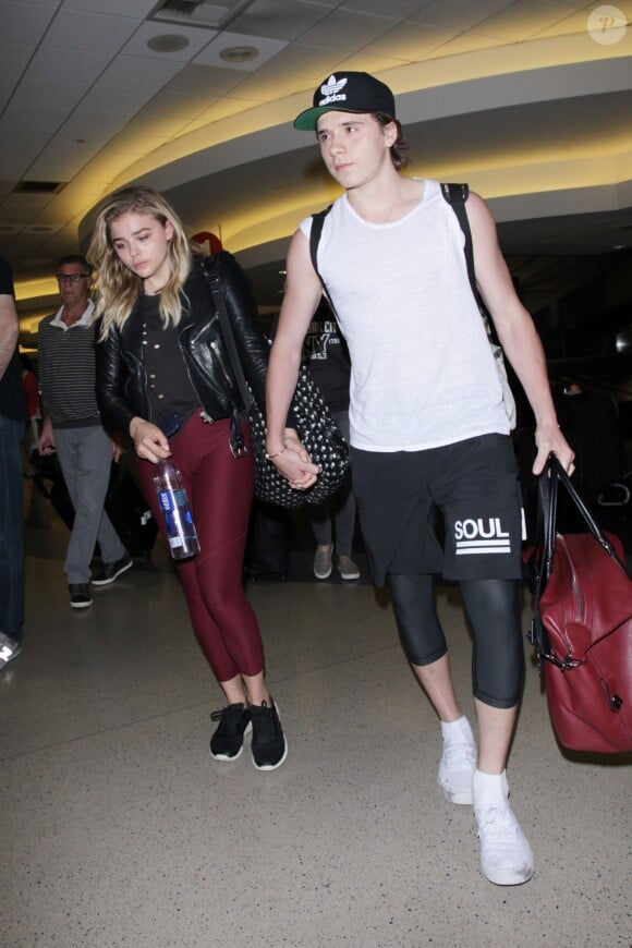 Chloë Grace Moretz et Brooklyn Beckham arrivent à l'aéroport de LAX main dans la main à Los Angeles, Californie, le 29 juin 2016.