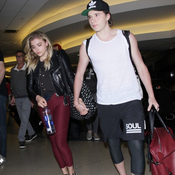 Chloë Grace Moretz et Brooklyn Beckham arrivent à l'aéroport de LAX main dans la main à Los Angeles, Californie, le 29 juin 2016.