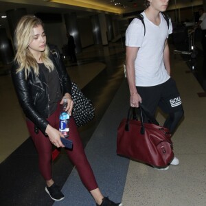 Chloë Grace Moretz et Brooklyn Beckham arrivent à l'aéroport de LAX main dans la main à Los Angeles, Californie, le 29 juin 2016.