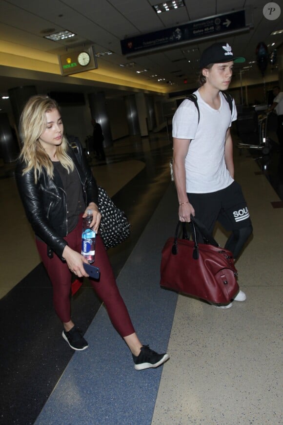 Chloë Grace Moretz et Brooklyn Beckham arrivent à l'aéroport de LAX main dans la main à Los Angeles, Californie, le 29 juin 2016.