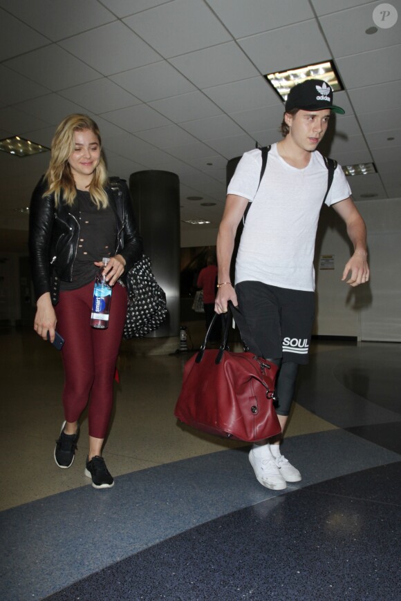 Chloë Grace Moretz et Brooklyn Beckham arrivent à l'aéroport de LAX main dans la main à Los Angeles, Californie, le 29 juin 2016.
