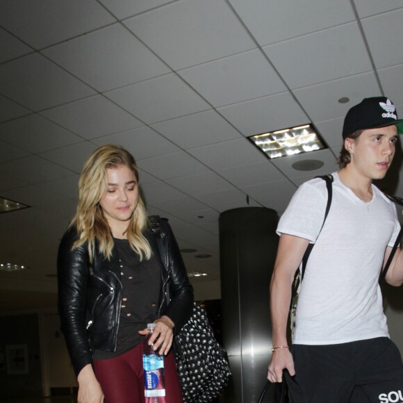 Chloë Grace Moretz et Brooklyn Beckham arrivent à l'aéroport de LAX main dans la main à Los Angeles, Californie, le 29 juin 2016.