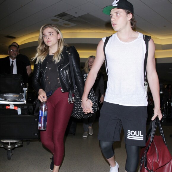 Chloë Grace Moretz et Brooklyn Beckham arrivent à l'aéroport de LAX main dans la main à Los Angeles, Californie, le 29 juin 2016.