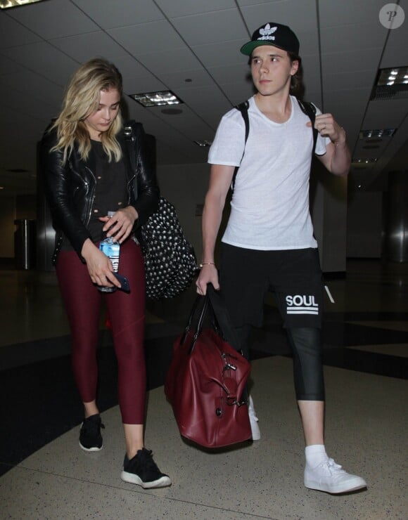Chloë Grace Moretz et Brooklyn Beckham arrivent à l'aéroport de LAX main dans la main à Los Angeles, Californie, le 29 juin 2016.