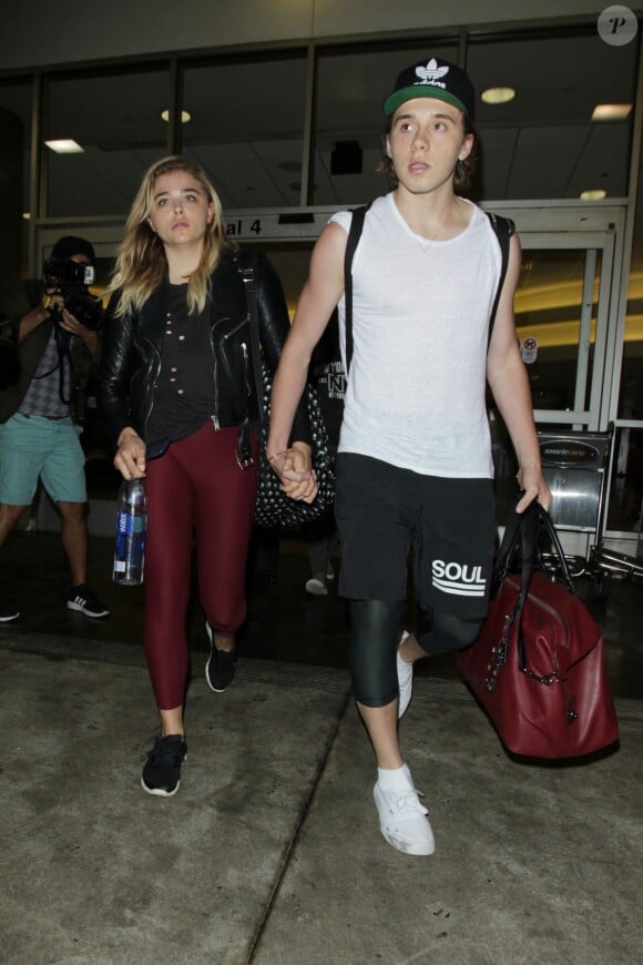 Chloë Grace Moretz et son compagnon Brooklyn Beckham arrivent à l'aéroport de LAX main dans la main à Los Angeles, Californie, le 30 juin 2016.