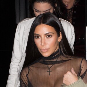 Kim Kardashian et Kendall Jenner sortant de la fête d'anniversaire de Mario Dedivanovic, maquilleur de Kim Kardashian au restaurant Kinu à Paris, le 1er octobre 2016. Kim Kardashian porte une tenue très transparente et sexy ainsi q'une croix autour du cou.