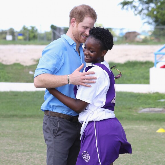 Le prince Harry rencontre une jeune fille au stade de cricket Sir Vivian Richards pendant le festival des sports pour la jeunesse à Saint John's, le 21 novembre 2016 à l'occasion de son deuxième jour de son voyage officiel de 15 jours dans les Caraïbes?  Prince Harry hugs a girl as he attends a youth sports festival at the Sir Vivian Richards Stadium in North Sound, Antigua, on the second day of his tour of the Caribbean.21/11/2016 - North Sound