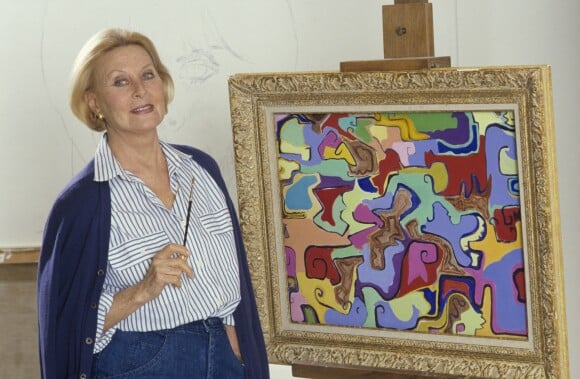 En France, à Neuilly-sur-Seine, Michèle Morgan chez elle, posant devant un de ses tableaux en novembre 1987.