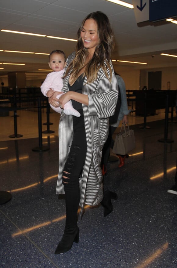 John Legend et sa femme Chrissy Teigen à l'aéroport de Los Angeles avec leur fille Luna le 26 décembre 2016.