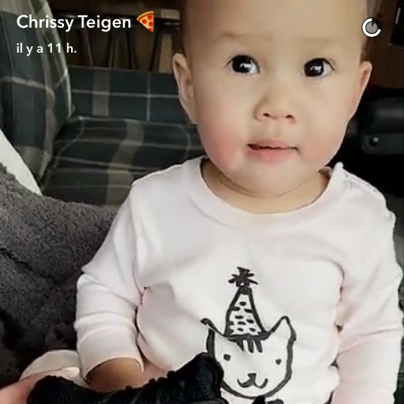 Chrissy Teigen dévoilant à Luna la paire de chaussures Yeezy envoyée par ses amis North et Saint West le 13 février 2017