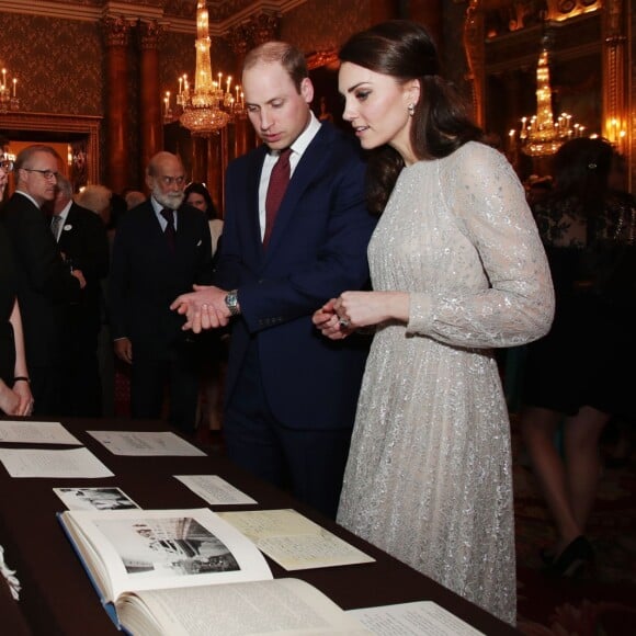 Le prince William et la duchesse Catherine de Cambridge observent un châle offert en 1961 à la reine Elizabeth II en Inde lors de la réception donnée le 27 février 2017 à Buckingham Palace en l'honneur du lancement de l'année culturelle UK - India et des 70 ans de l'indépendance de l'Inde.