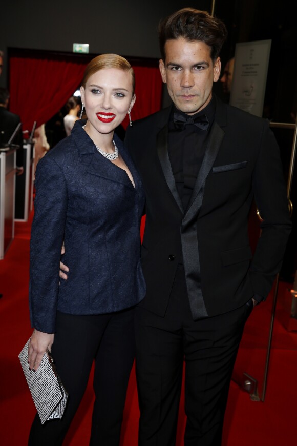 Scarlett Johansson (César d'honneur) (habillée avec une veste « Bar » en dentelle bleu marine, pantalon en crêpe de soie bleu marine et une pochette Dior) et Romain Dauriac - 39ème cérémonie des César au théâtre du Châtelet à Paris, le 28 février 2014.