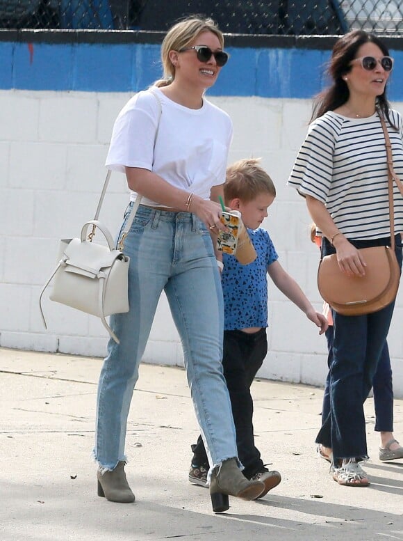 Exclusif - Hilary Duff, en t-shirt blanc, jean et bottines, emmène son fils Luca au cinéma et faire du shopping à Studio City. Un sac Céline et des lunettes de soleil accessoirisent sa tenue. Le 10 mars 2017.