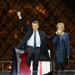 Emmanuel Macron, élu président de la république, et sa femme Brigitte Macron (Trogneux), saluent les militants devant la pyramide au musée du Louvre à Paris, après sa victoire lors du deuxième tour de l'élection présidentielle. Le 7 mai 2017.