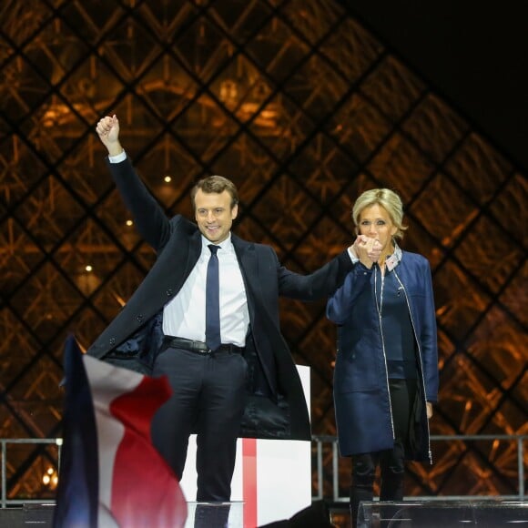 Emmanuel Macron, élu président de la république, et sa femme Brigitte Macron (Trogneux), saluent les militants devant la pyramide au musée du Louvre à Paris, après sa victoire lors du deuxième tour de l'élection présidentielle. Le 7 mai 2017.