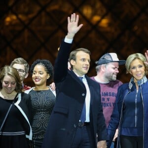 Morgan Simon (l'homme à la casquette), Emmanuel Macron, élu président de la république, et sa femme Brigitte Macron (Trogneux), saluent les militants devant la pyramide au musée du Louvre à Paris, après sa victoire lors du deuxième tour de l'élection présidentielle. Le 7 mai 2017.