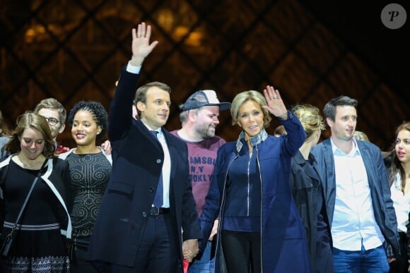 Morgan Simon (l'homme à la casquette), Emmanuel Macron, élu président de la république, et sa femme Brigitte Macron (Trogneux), saluent les militants devant la pyramide au musée du Louvre à Paris, après sa victoire lors du deuxième tour de l'élection présidentielle. Le 7 mai 2017.
