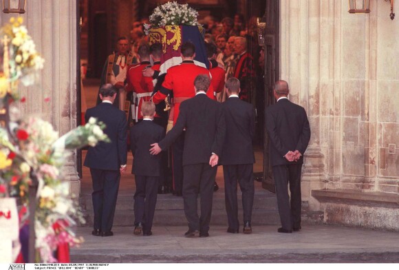 Charles Spencer passant une main réconfortante dans le dos du prince Harry à l'entrée de l'abbaye de Westminster... Le prince William et le prince Harry, alors âgés de 15 et 12 ans, ont dû marcher derrière le cercueil de leur mère la Lady Diana en public avec le duc d'Edimbourg, le prince Charles et le comte Charles Spencer, pendant une interminable demi-heure lors des obsèques nationales de la princesse le 6 septembre 1997 à Londres. "Bien sûr qu'ils ne voulaient pas faire ça", a révélé en juillet 2017 leur oncle Charles Spencer.