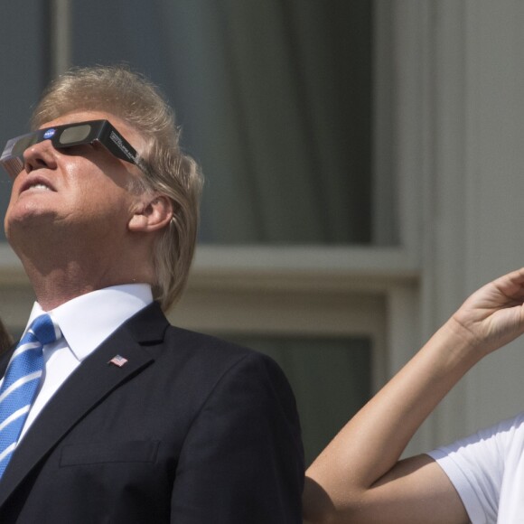 Le président Donald Trump, sa femme Melania Trump, leur fils Barron Trump et sa fille Ivanka Trump regardent l'éclipse solaire totale au balcon présidentiel de la maison Blanche à Washington, le 21 août 2017.