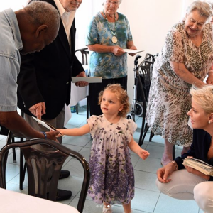 La princesse Charlene de Monaco a rendu une visite surprise avec ses jumeaux le prince Jacques et la princesse Gabriella, qui remet ici une photo à un pensionnaire, aux aînés de la Fondation Hector Otto le 19 août 2017. © Instagram HSH Princesse Charlene de Monaco / Eric Mathon / Palais Princier