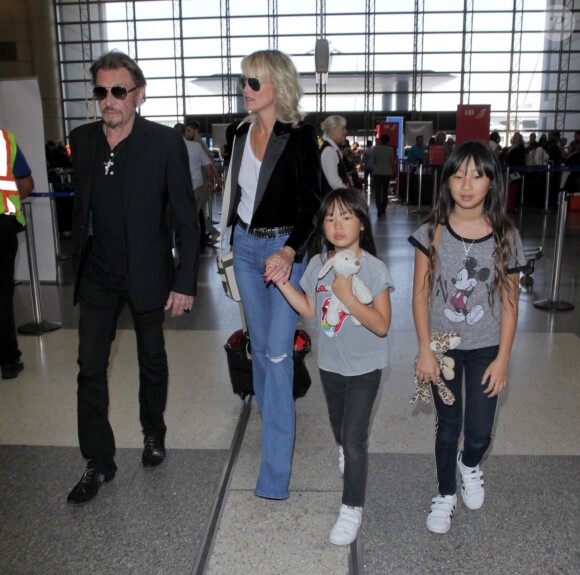 Johnny Hallyday avec sa femme Laeticia et ses enfants Jade et Joy en partance pour Paris arrivent à l'aéroport Lax de Los Angeles le 25 juin 2016.