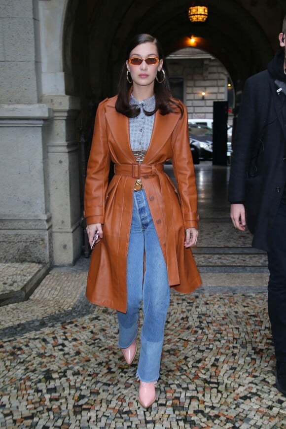 Bella Hadid porte des lunettes Le Specs (modèle "Outta Love"), un trench-coat en cuir et un jean RE/DONE à Milan. Le 22 février 2018.