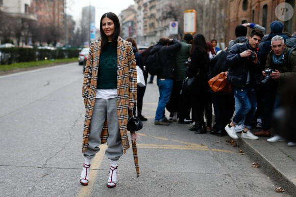 Gilda Ambrosio porte un manteau, un pull et un jogging Burberry (collection capsule de février) à Milan, le 21 février 2018.
